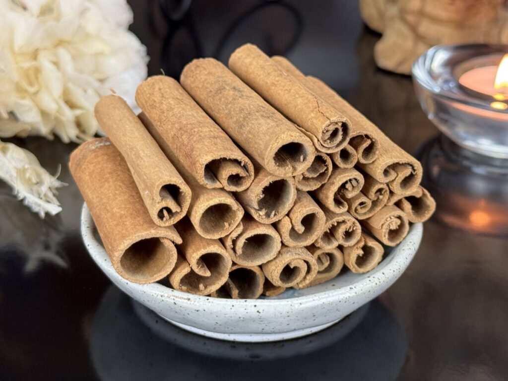 Paus de canela e pó sobre uma mesa, utilizados como alimento termogênico para equilibrar o metabolismo
