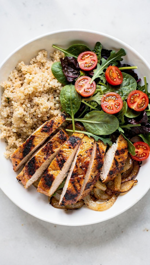 Bowl saudável com frango grelhado, quinoa e salada fresca de folhas e tomates, opção nutritiva para a dieta de resistência à insulina