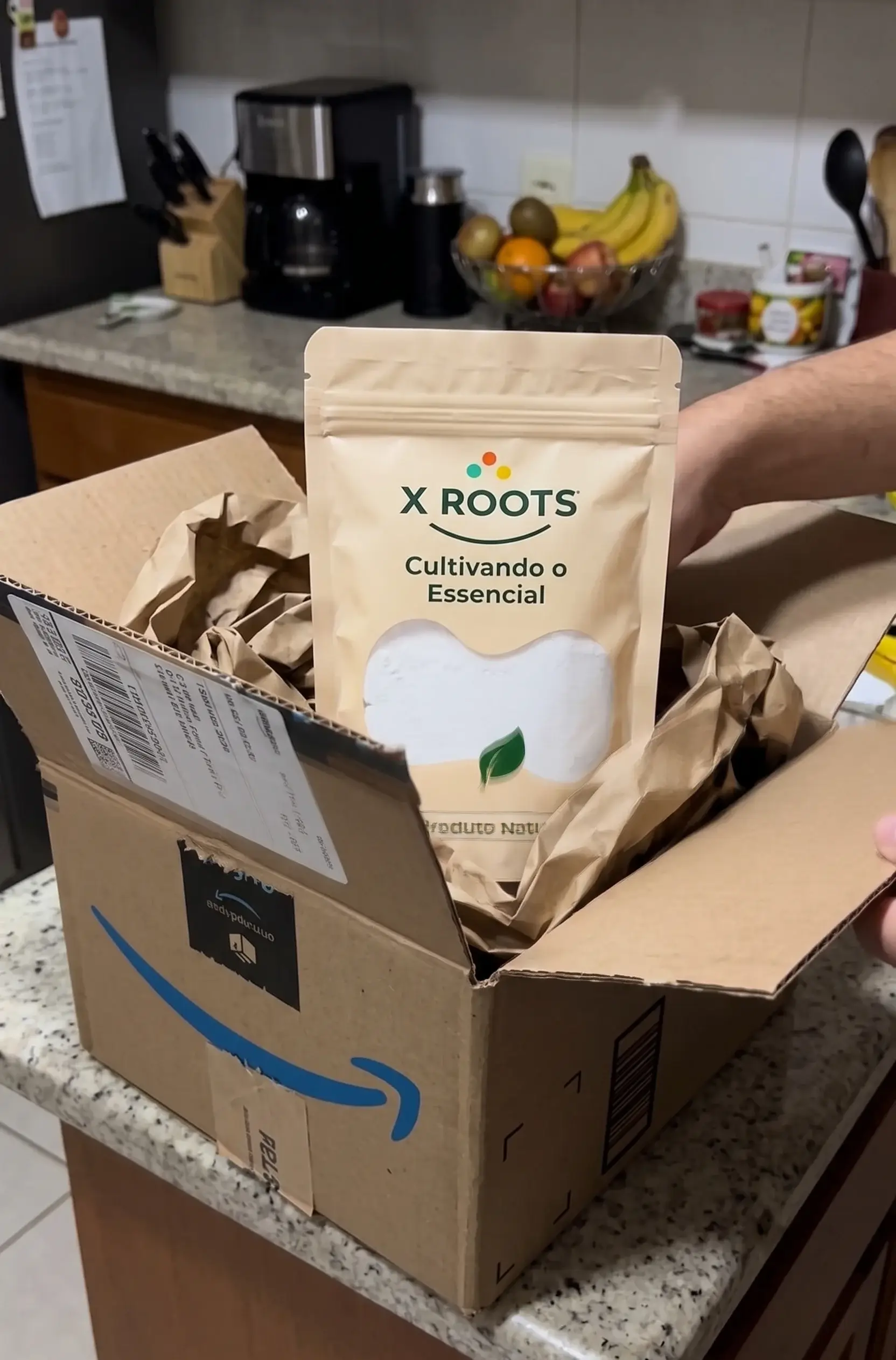 Pacote de Inulina em Pó da X Roots de 500g sendo retirado de uma caixa de entrega da Amazon na cozinha.