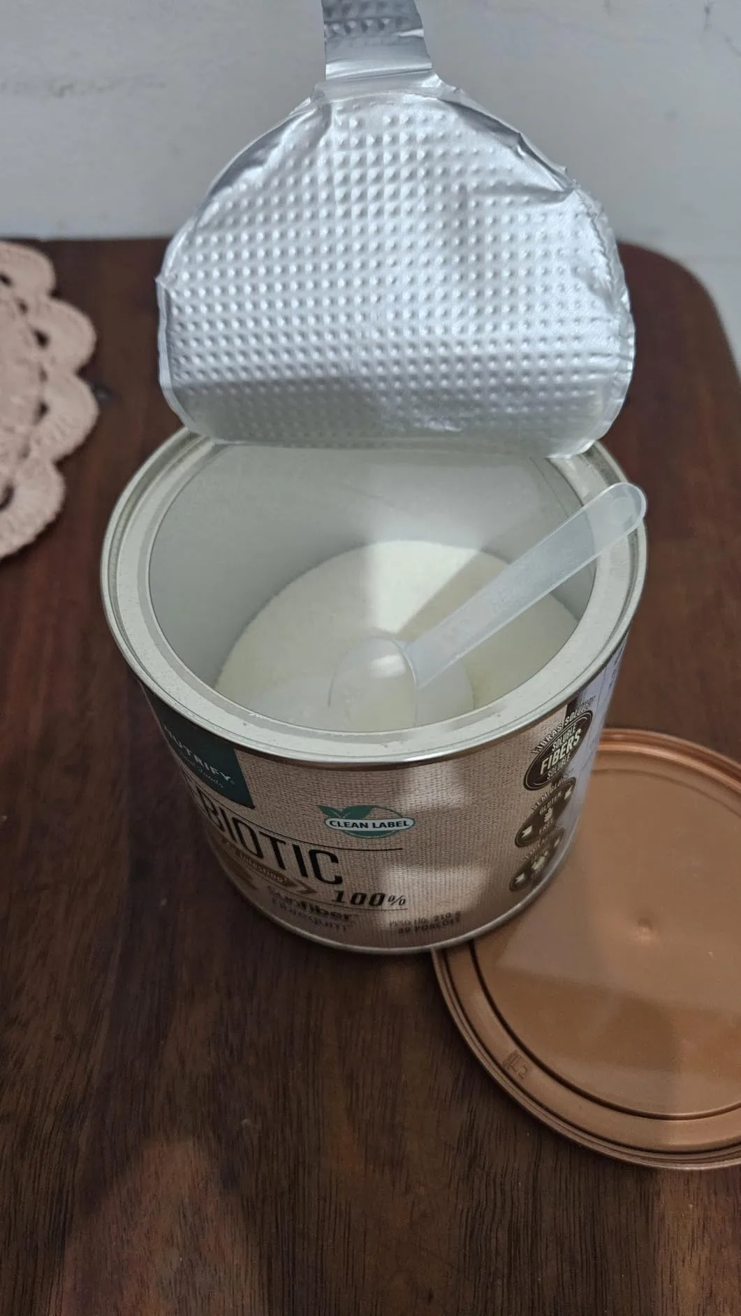 Lata de Fibras Prebióticas da Nutrify aberta mostrando o medidor scoop interno e o pó solúvel neutro para saúde intestinal.