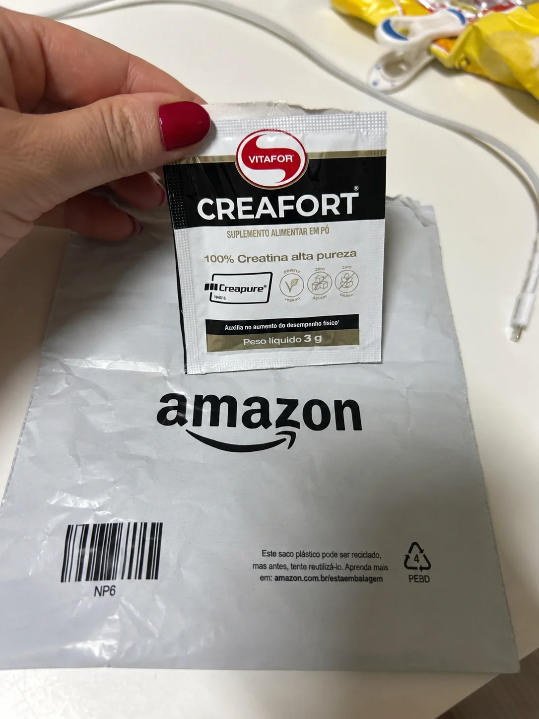 Sachê de Creatina Creafort Vitafor Creapure 3g sobre envelope de entrega da Amazon